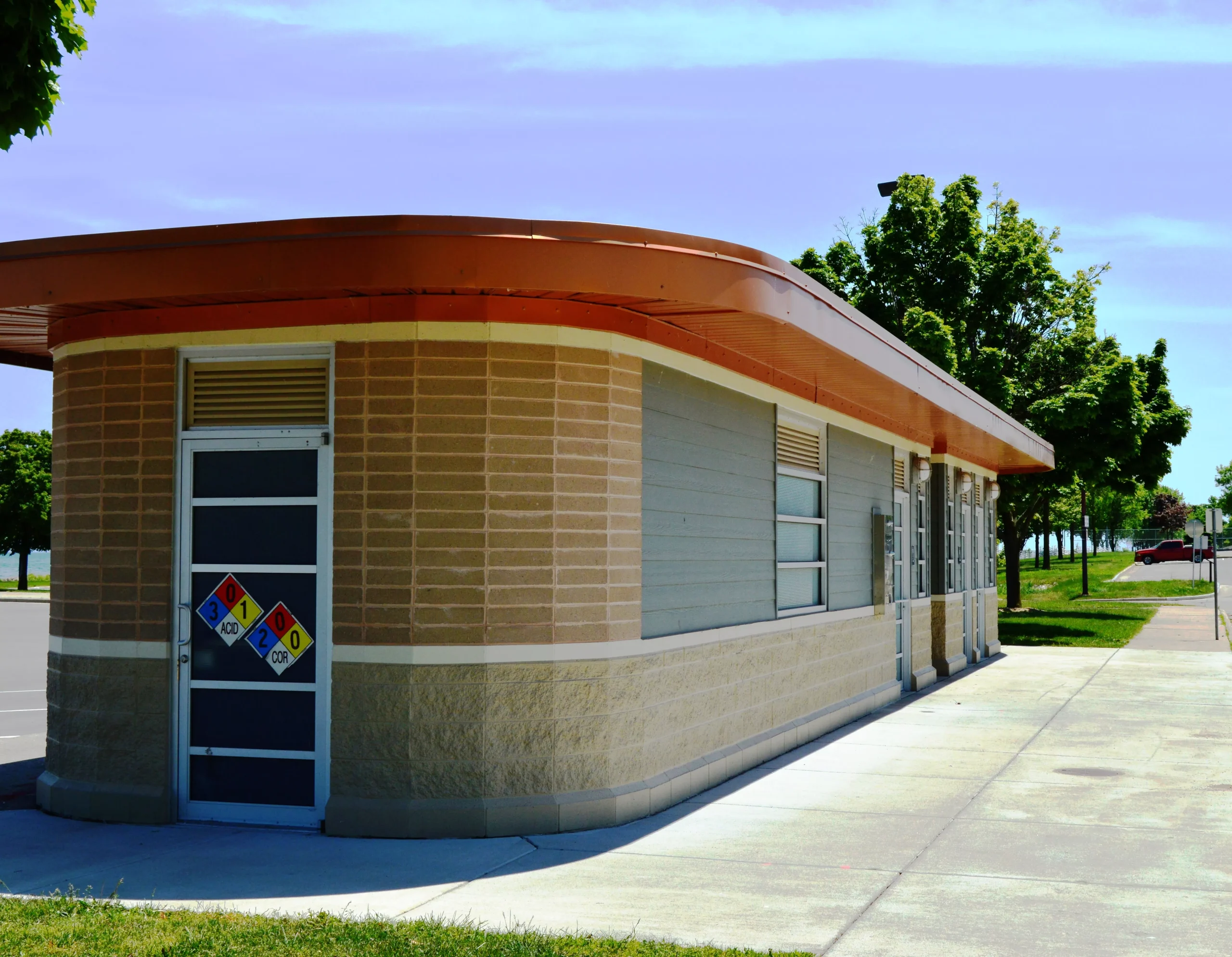 Domino's Pizza carryout building with drive-through window, brick and concrete exterior, and orange roof.