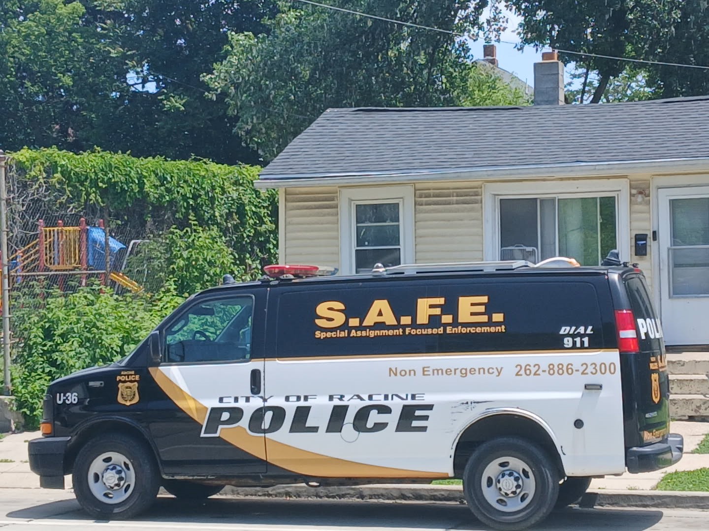 Racine Police S.A.F.E. van parked in front of a house. Contact information is displayed on the vehicle.
