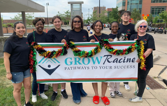 Group of students holding a Grow Racine banner with Pathways to Your Success written on it.