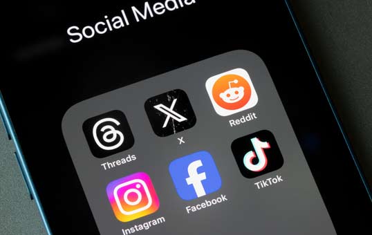 Smartphone screen displaying icons for social media apps: Threads, X, Reddit, Instagram, Facebook, and TikTok.